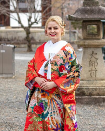 Une mariée en rouge, rayonnante dans sa tenue de cérémonie. Fleurs, oiseaux, broderies et couleurs éclatantes se mêlent sur le kimono, tandis que son sourire vient illuminer l’ensemble. #MariageAuJapon #MariageJaponais #KimonoJaponais #MarieeAuJapon #MariageAKyoto #KimonoDeMariage #KyotoWedding #JapaneseWedding #JapanWedding #WeddingInJapan #PortraitDeMariee #TraditionsJaponaises #KimonoCeremonie